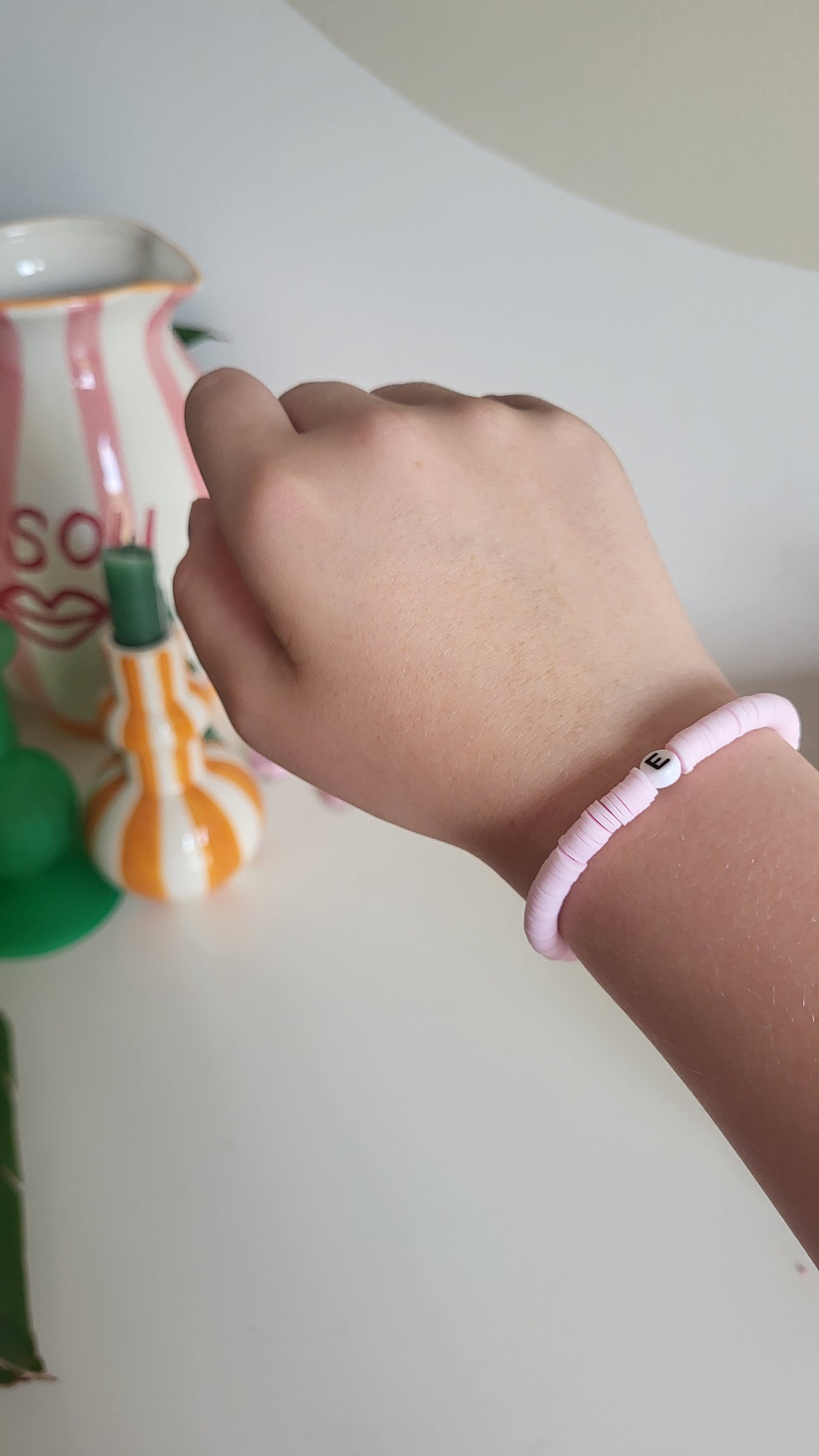 A light pink bracelet with "E" charm