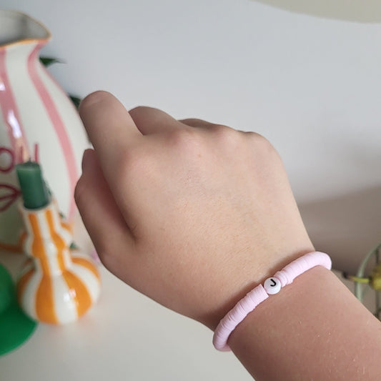 A light pink bracelet with "J" charm